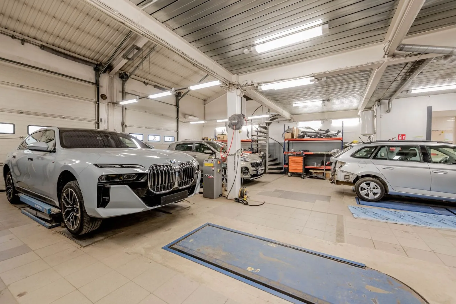 Avariiautoabi kere- ja värvitöökoda Telliskivil: valged sõiduautod remondiboksides